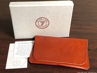 Wallet on box with care card and Seven+Ash logo visible