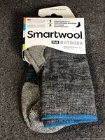 Front of packaged Smartwool PhD Outdoor socks showing branding and size small info