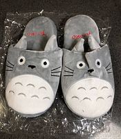 Top view of grey Totoro slippers showing embroidered faces and white belly pattern