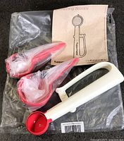 Three red and white Tupperware portioning scoops in original plastic with instruction sheet
