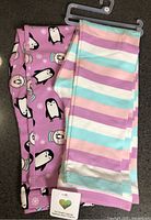 Both leggings folded, showing patterns and hang tag