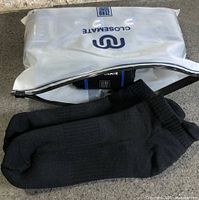 Resealable Closemate pouch and one pair of black socks displayed