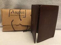 Wallet closed beside branded kraft paper pouch