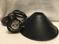 Entire pendant fixture disassembled showing black matte shade and LED-style socket face