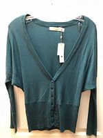 Front view of dark teal V-neck button cardigan with tags attached