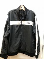 Front view of black FILA wind jacket on hanger