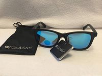 Sunglasses front view with pouch and tags visible
