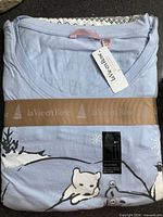 Folded pajama set with ribbon, tags visible