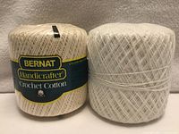 Two Bernat crochet cotton balls side by side, labelled ecru and unlabelled white