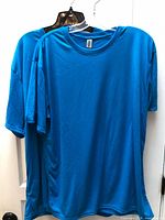 Front view of both identical blue Gildan t-shirts on hangers