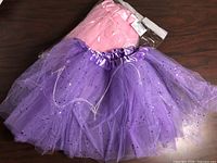Purple and packaged pink tutus on table