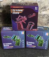 Front view of all three boxed Frisbee Guns