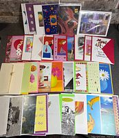 Overview of assorted greeting cards laid out showing front designs and envelopes