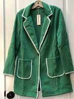 Full view of green Luvamia peacoat hanging, showing front and trim