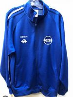 Front view of blue Adidas Hellas track jacket on hanger