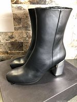 Side view of both boots showing leather uppers and chrome heels