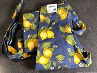 Folded apron showing lemon pattern and original tag