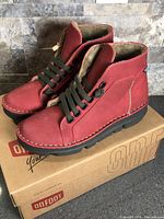 Side view of both red OnFoot boots on box