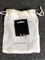 Earrings on display card with Pilgrim pouch