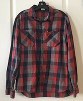 Front view of Rab plaid shirt hanging
