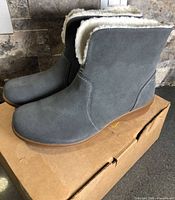 Side view of grey suede Spenco ankle boots on box