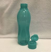 Front view with cap removed showing bottle and lid