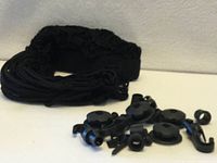 coiled black cargo net with separate mounting hardware pieces