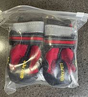Sealed bag showing four red and black dog boots