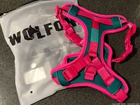 Front view of Wolfone pink and teal dog harness with storage bag