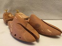 Side view of cedar shoe trees showing split-toe and brass knobs