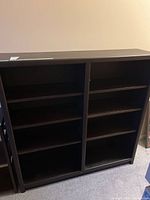 Front view of large dark wood bookcase showing shelving layout