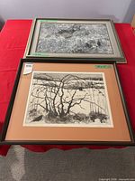 Two framed artworks displayed on table
