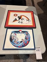 Both framed prints on table