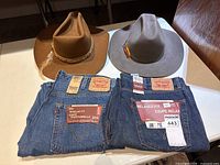 Overview of both pairs of jeans and two cowboy hats