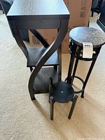 All three pieces grouped: tall wood accent table, metal plant stand with faux-marble top, low round wood table