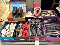 Assorted shoes in boxes showing variety of pairs