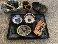 Group shot of tray with colourful dishes, fish bowl, tumblers and wooden spreaders