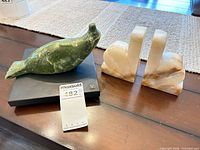 Soapstone seal sculpture and pair of marble bookends on table