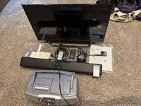 Sony 32" TV on stand, Polk soundbar, Sony boombox, cables, remotes, manuals