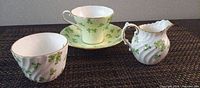 Group shot of teacup, saucer, creamer and sugar bowl displaying pattern and condition