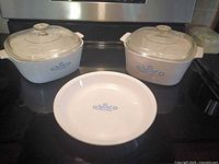 Front view of both casseroles with lids and pie plate