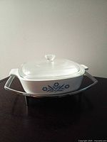 Casserole dish with lid on chrome stand, frontal view showing blue cornflower motif