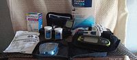 Group shot of all diabetes supplies including meters, lancets box, sensor covers pouch, test strip vials, lancing device and cases