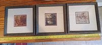 Front view of all three framed prints with tape measure for scale