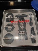 Front of sealed Metrokane Velvet Wine Tool Kit showing tools through clear lid