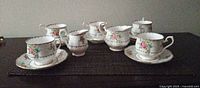 Entire grouping of five cup-saucer sets with two pitchers