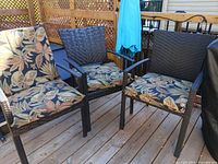 Three wicker patio chairs fitted with the botanical print cushions
