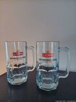 Two clear glass Sleeman beer mugs front view showing logo