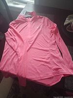 Full view of long-sleeve coral pink quarter-zip pullover laid flat