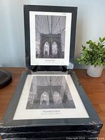 Front view of two sealed black frames with paper inserts